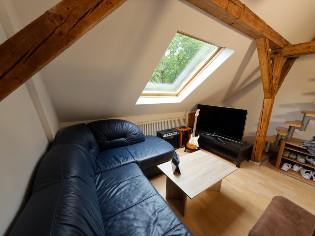 Musikzimmer im Dachgeschoss mit Schlafsofa und Fernseher